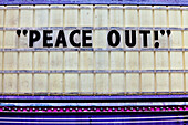 Queen Anne, Seattle, Washington, USA. A close theatre marquee, with a peace message.  Glazed tiles slogan., Tiled Sign, Peace Out!