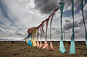 Prayer Flags arranged in a long line on a rope in a Yak field on the road to Hongyuan., Qinghai Tibet