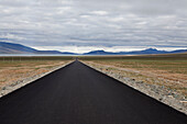 The road to Mount Kailash in Western Tibet. A long straight tarmac metalled road through a flat landscape, Mountains., Road, Western Tibet, Tibet Autonomous Region