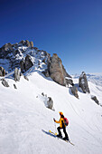 Woman backcountry skiing, ascending towards notch Schweizer Tor, view towards Drusenfluh, St. Antoenien, Praettigau, Grisons, Switzerland