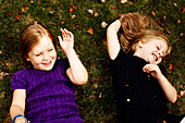 Two Young Girls Laying on Grass