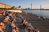 Menschen sitzen auf der Treppe zur Rheinuferpromenade, Düsseldorf, Nordrhein-Westfalen, Deutschland, Europa