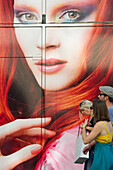 People in front of a giant poster in the shopping area, Strasbourg, Alsace, France