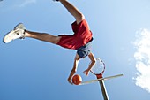 Teenager jumping with basketball