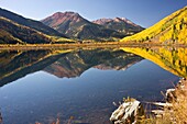 Rocky Mountain foliage reflects in a clear mountain lake