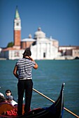 Gondolier at work in front of San Giorgio Maggiore, Venice, Italy
