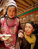 Women drinking tea in the courtyard, Hemis Festival at convent Hemis, southeast of Leh, Ladakh, Jammu and Kashmir, India