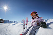 Mädchen (3 Jahre) sitzt im Schnee, Montafon, Silvretta, Sankt Gallenkirch, Vorarlberg, Österreich