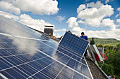 Zwei Personen installieren eine Solaranlage, Freiburg im Breisgau, Schwarzwald, Baden-Württemberg, Deutschland, Europa