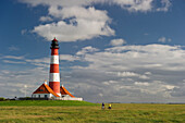 Westerheversand lighthouse and cyclists, Westerhever, Wadden Sea National Park, Eiderstedt peninsula, North Frisian Islands, Schleswig-Holstein, Germany, Europe