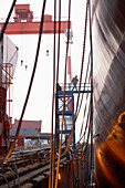 Chinesische Werftarbeiter betreten Frachter über Treppengerüst, Ouhua Werft in Zhoushan, Zhejiang Provinz, China