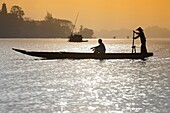 Man in conical hat ferries passenger across Song Huong Perfume River Hue central Vietnam