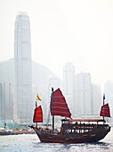 An old style Hong Kong Junk boat sails in Victoria Harbour in Hong Kong