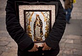 A pilgrim carries an image of the Our Lady of Guadalupe outside of the Our Lady of Guadalupe Basilica in Mexico City, December 11, 2011  Hundreds of thousands of Mexican pilgrims converged on the Basilica, bringing images to be blessed, as processions fil
