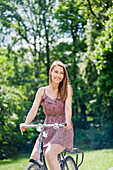 Pretty woman riding a bike in the park