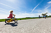 Children cycling, parents standing in background, Upper Bavaria, Germany
