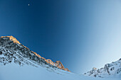 Lisenser Fernerkogl, Brunnenkogl and Bachfallenkopf in winter with half moon at sunset, view from Laengental valley, Sellrain, Innsbruck, Tyrol, Austria