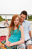 Young couple on bank of Isar river, Munich, Bavaria, Germany