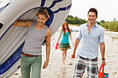 Junge Leute gehen der Isar entlang mit dem Schlauchboot, München, Bayern, Deutschland