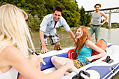 Junge Leute mit einem Schlauchboot an der Isar, München, Bayern, Deutschland