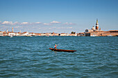 Ein Gondoliere rudert seine Gondel über den Canale della Guidecca, Venedig, Venetien, Italien, Europa