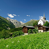 Church and traditional houses in front of the Bernese Alps, Ernen, Binn valley, Rhone valley, Valais, Switzerland