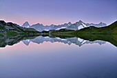 Mont Blanc range with Grandes Jorasses and Mont Dolent reflecting in a mountain lake, Pennine Alps, Aosta valley, Italy