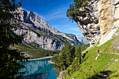 A man hiking at lake Oeschinen, Bernese Oberland, Canton of Bern, Switzerland