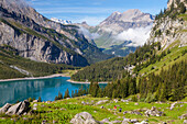 Ein Mann und eine Frau beim Wandern am Oeschinensee, Alp Unterbärgli, Blick zum Wildstrubel, Berner Oberland, Kanton Bern, Schweiz