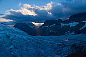 Eine Seilschaft im Hintergrund, zwei Bergsteiger mit Stirnlampe auf dem Kanderfirn im Mondlicht, Aufbruch von der Mutthornhütte, Berner Oberland, Kanton Bern, Schweiz