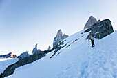 Mann steigt über vergletschertes Gelände zum Hochlager am Passo Superior auf, Fitz Roy Massiv, El Chalten, Patagonien, Argentinien