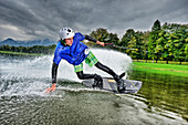 Junger Mann surft auf Wakeboard, Wakeboarding, Neubeurer See, Neubeuern, Rosenheim, Oberbayern, Bayern, Deutschland