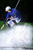 Young man surfing on a wakeboard, wakeboarding at lake Neubeurer See, Neubeuern, Rosenheim, Upper Bavaria, Bavaria, Germany