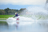 Young man surfing on a wakeboard, wakeboarding at lake Neubeurer See, Neubeuern, Rosenheim, Upper Bavaria, Bavaria, Germany