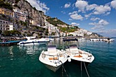 Boats in the harbour and a view of the town of Amalfi on the Gulf of Salerno in southern Italy