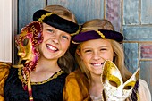 Preteen sisters dressed in medieval costumes and holding Carnival masks, Cedar City, Utah USA  Cedar City is home to the Tony Award-winning Utah Shakespeare Festival
