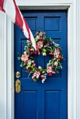 Flower wreath on door with American flag, Lewes, Delaware, USA