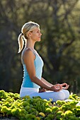 Woman performs yoga at Makena, Maui, Hawaii