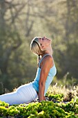 Attractive woman performs yoga at Makena, Maui, Hawaii