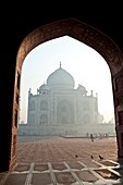 Taj Mahal in the morning mist view through the arch of the mosque, Agra, India