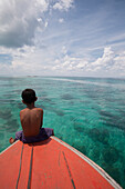 Young Boy Sitting at Front of Boat and Looking out to Sea, Borneo
