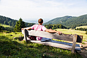 Man sitting on a bench, Hochries, Riesen hut, Frasdorf, Chiemgau, Bavaria, Germany