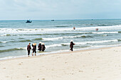 Monks walking along the beach at the coast of Mui Ne, south Vietnam, Vietnam, Asia