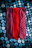 Three Red Patterned Ties on Dotted Fabric