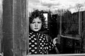 Young Girl With Curly Hair Looking out Window