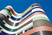 A city building in Melbourne. The exterior wall with patterned coloured panels, of tiling. Low angle view.