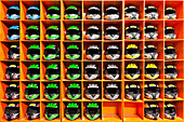 Shelves filled with helmets for hire, at an indoor karting track in an active gaming center, Safety equipment, storage
