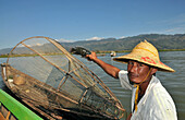 Fisherman showing the fish he caught on the Inle Lake, Myanmar, Burma, Asia