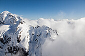 Helicopter flight over snowy mountains with low cloud, Bryneira Range, Southern Alps, South Island, New Zealand