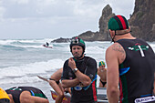 Surfers at a competition with coxswain Mark Bourneville, surf boats, Day of the giants, Piha Beach, Auckland, North Island, New Zealand